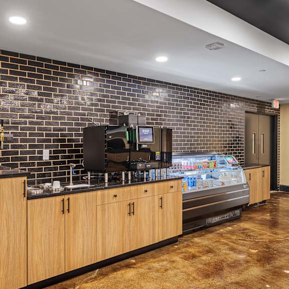 a lobby with a coffee machine and a brick wall