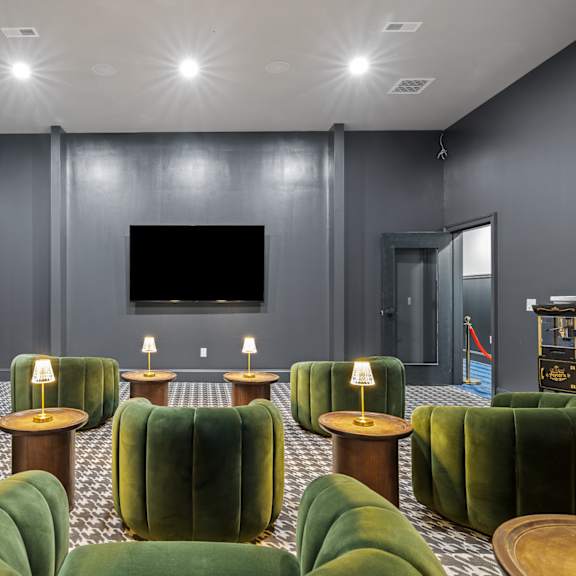 a living room with green chairs and a television