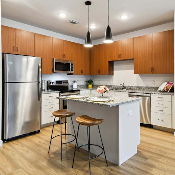 Thumbnail 2 of 4 a kitchen with a island and two stools at Gibson Oaks, Lakeland, 33809