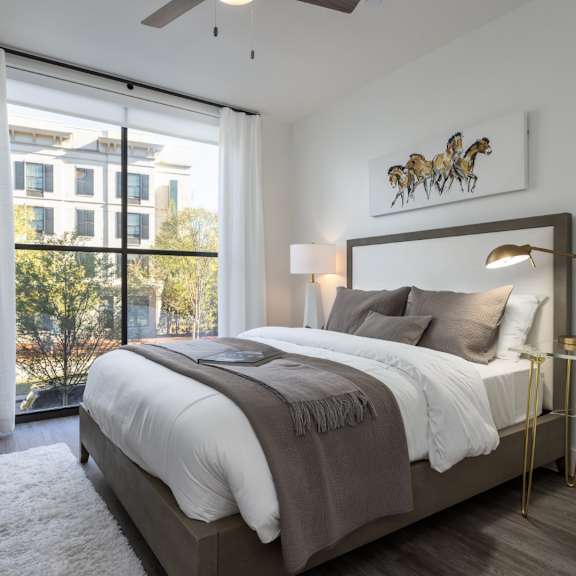 Thumbnail 5 of 6 modern bedroom with natural light, ceiling fan, and wood plank flooring at 2020 Providence in Huntsville, AL