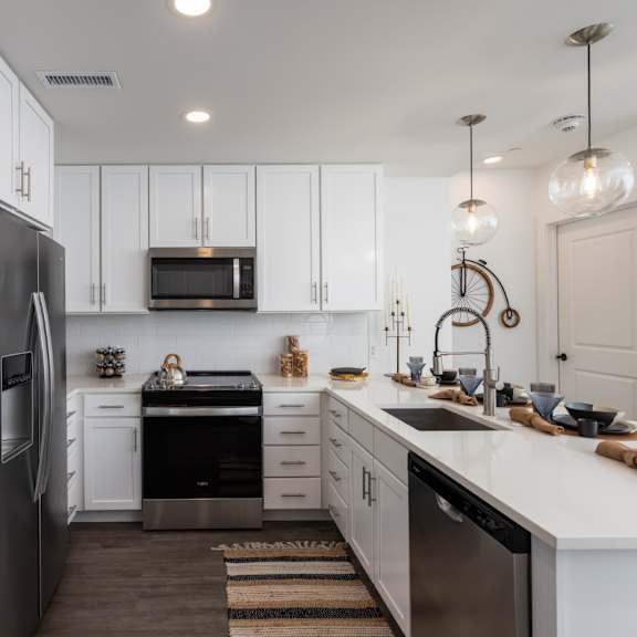 Thumbnail 3 of 6 A modern kitchen with white cabinets and stainless-appliances at 2020 Providence in Huntsville, AL