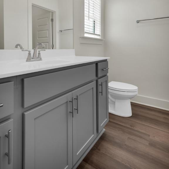 Thumbnail 6 of 9 A bathroom with a white toilet and a sink with a mirror at Turnberry Park Luxury Rental Homes