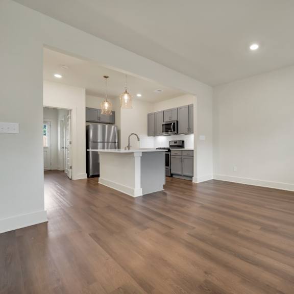 Thumbnail 4 of 9 A kitchen with a white countertop and wooden floors at Turnberry Park Luxury Rental Homes.