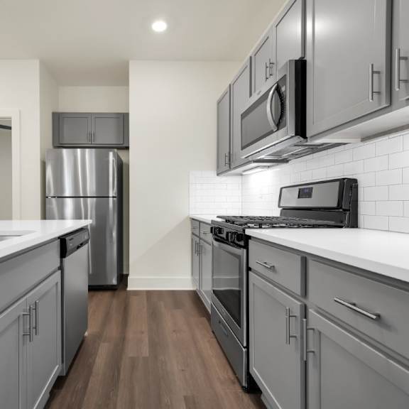 Thumbnail 3 of 9 A modern kitchen with a stainless steel refrigerator and a white countertop at Turnberry Park Luxury Rental Homes.
