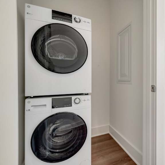 Thumbnail 12 of 13 A white front load washing machine in a laundry room at Turnberry Park Luxury Rental Homes