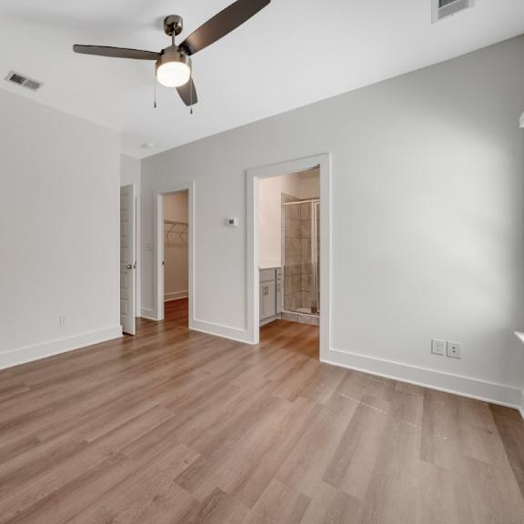 Thumbnail 7 of 13 A bedroom with a ceiling fan and wooden flooring.