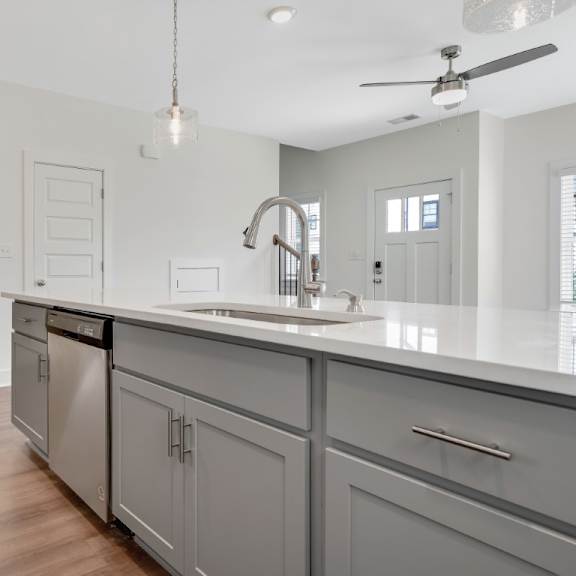 Thumbnail 4 of 13 A modern kitchen with a refrigerator, sink, and cabinets at Turnberry Park Luxury Rental Homes