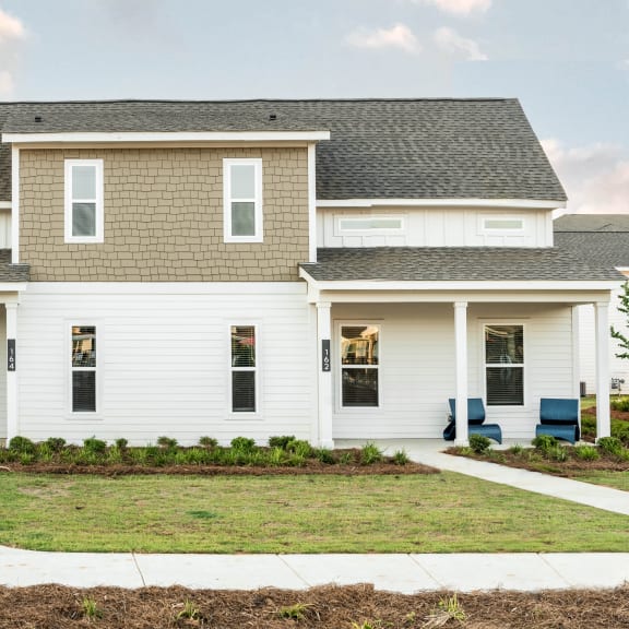 Thumbnail 3 of 3 Exterior view of a townhome-style home with private entrance, covered front-porch, and yard