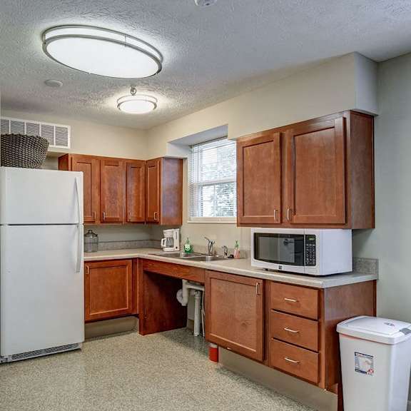 a kitchen with a white refrigerator and brown cabinets.