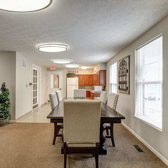 a living room with a couch, chairs, and a dining table.