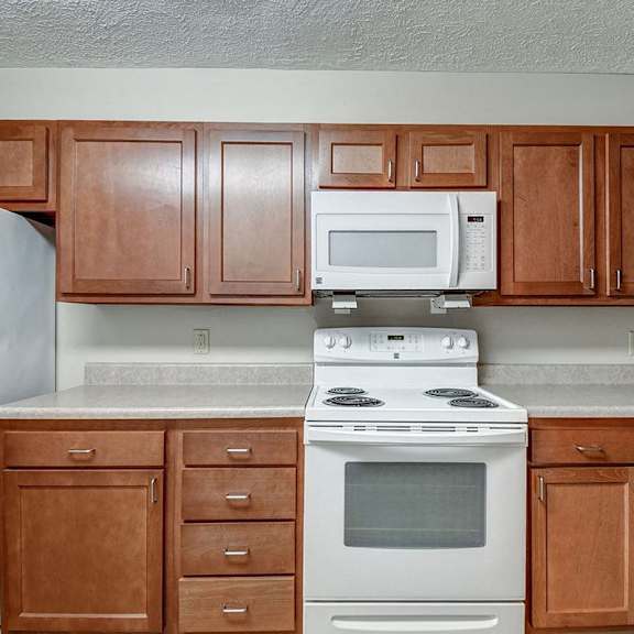 a kitchen with a white stove top oven and white microwave above it.