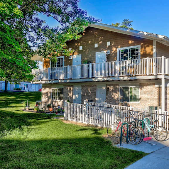 a large house with a balcony and two bikes parked in front of it