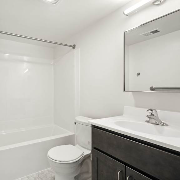 a white bathroom with a toilet, sink, and bathtub.