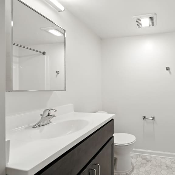 a white sink with a silver faucet is in a bathroom with a white toilet and a white shower.