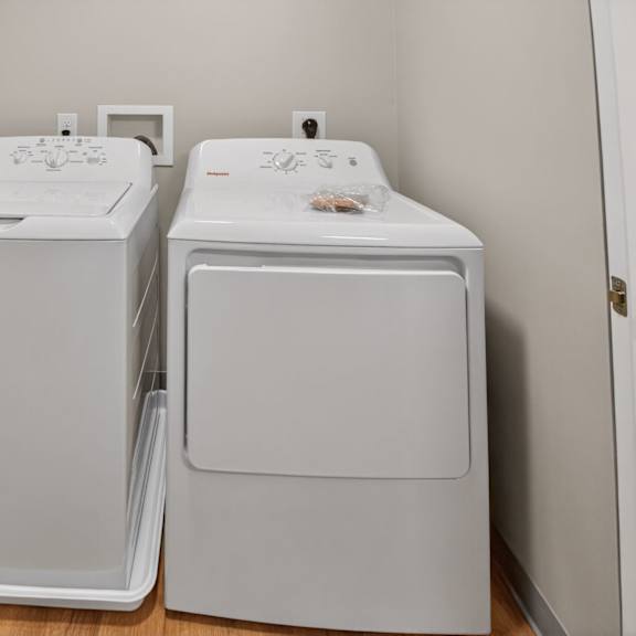 two white front loading washing machines in a laundry room.
