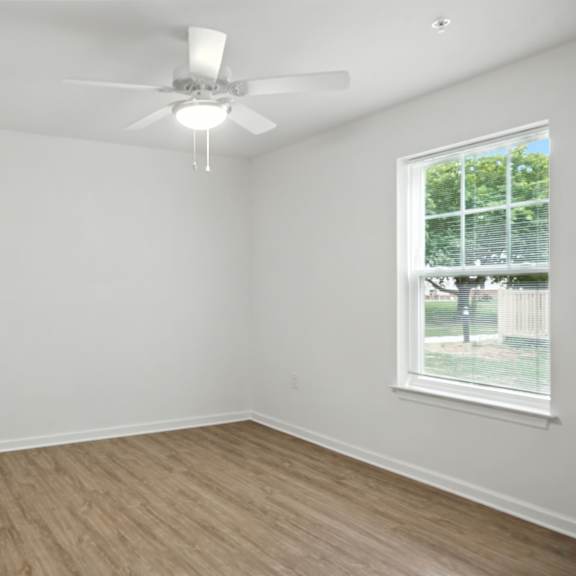 a room with a ceiling fan and a window.