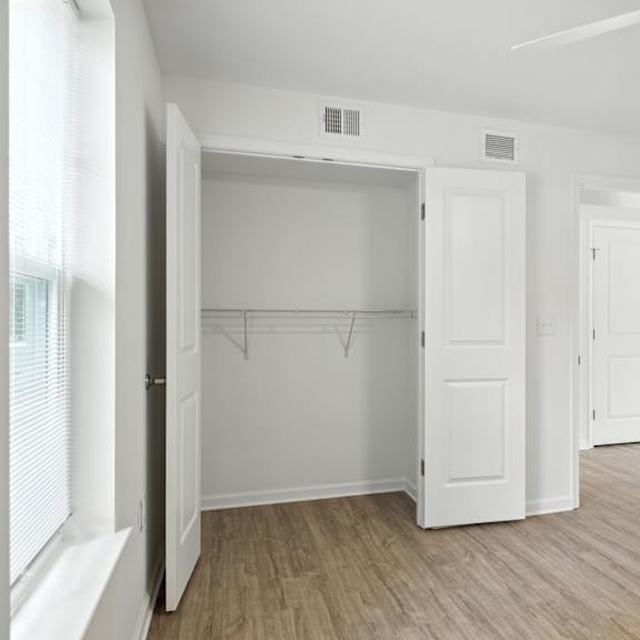 a white room with a ceiling fan and wooden flooring.