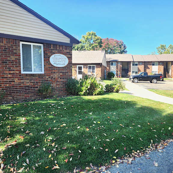 a view of the front of a brick building with a lawn