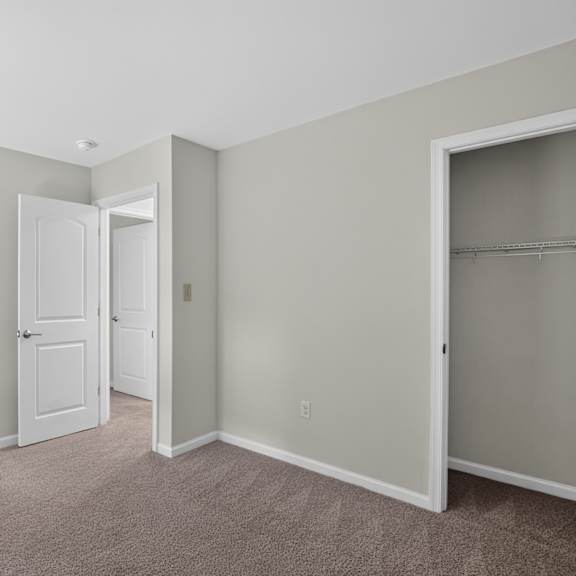 a room with a carpeted floor and two open doors.
