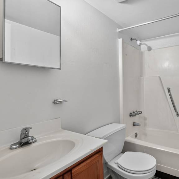 a white bathroom with a toilet, sink, and bathtub.