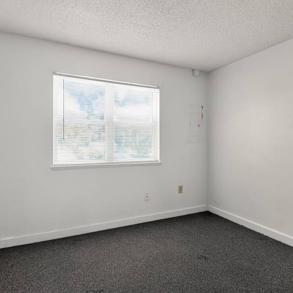 a room with a window and a carpeted floor.