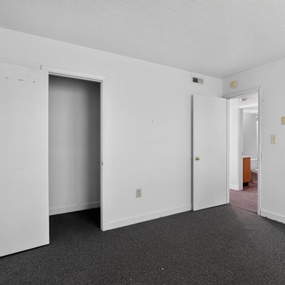 a room with white walls and a grey carpet.