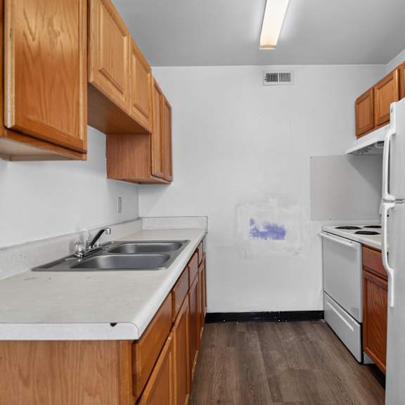 a kitchen with wooden cabinets and a white refrigerator.