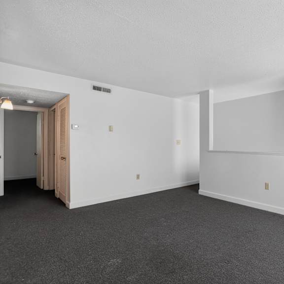 a room with a door on the left and a wall with a window on the right.