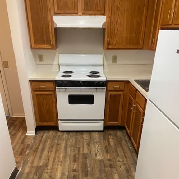 a kitchen with a white stove top oven and white refrigerator.