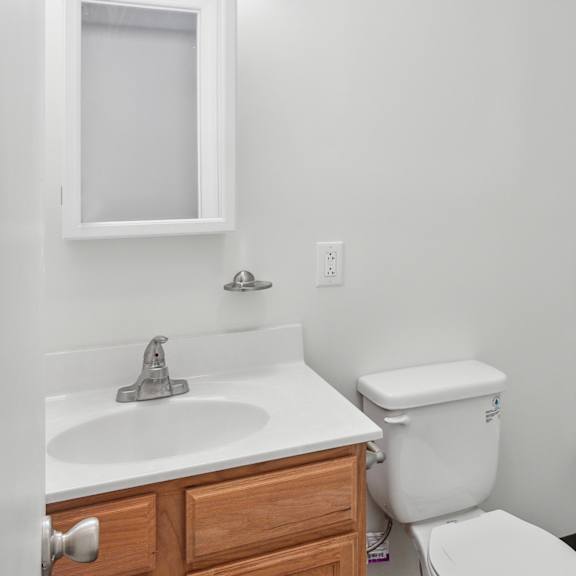 a white toilet sits next to a sink in a bathroom.