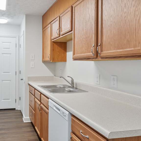a kitchen with white appliances and wooden cabinets.