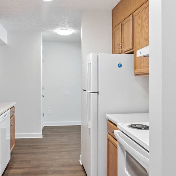 a kitchen with wooden cabinets and white appliances.