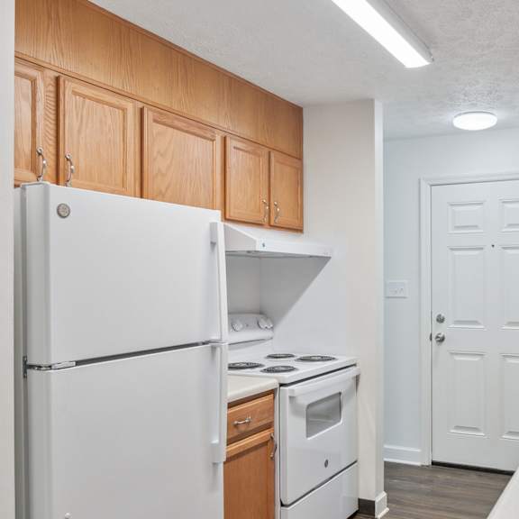 a kitchen with white appliances and wooden cabinets.
