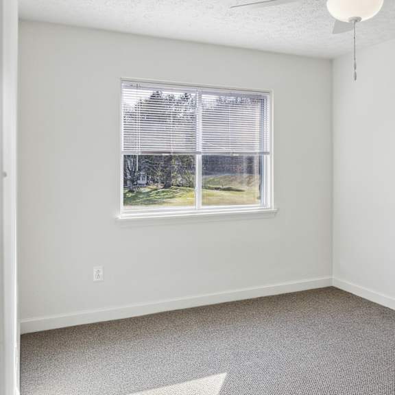 a room with a window and a ceiling fan.