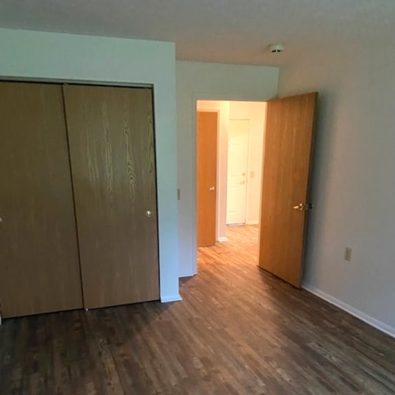 a hallway with a wooden floor and two doors.