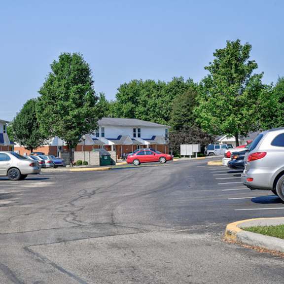 a parking lot with cars and a building in the background.