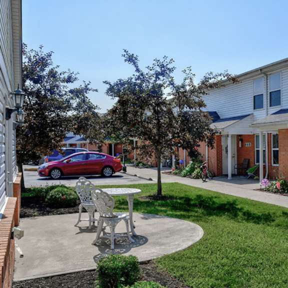 a red car is parked in a driveway next to a house.