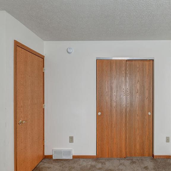 a room with two doors and a carpeted floor.