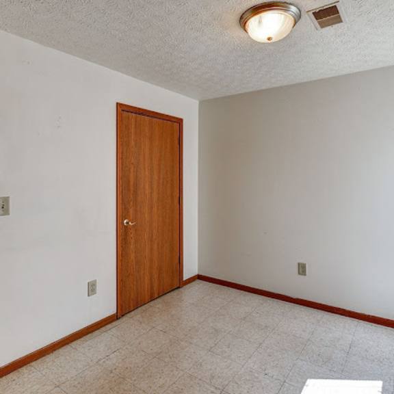 a room with a brown door and a light on the ceiling.