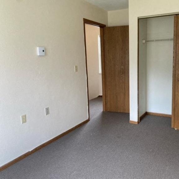 an empty living room with a door to a closet
