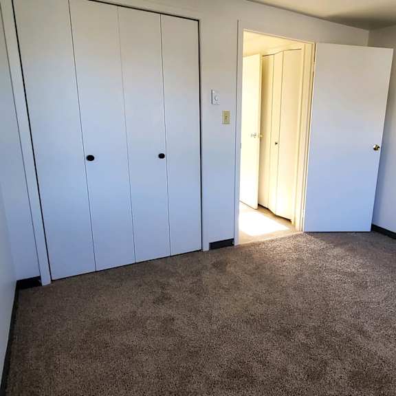 a bedroom with two closets and a door to a hallway
