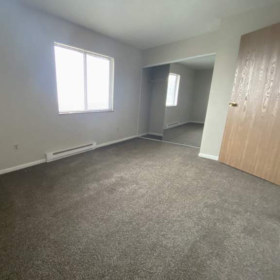 an empty room with a door and a window