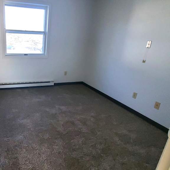 a room with a carpeted floor and a window
