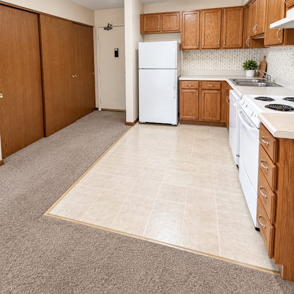 a kitchen with a white refrigerator and wooden cabinets.