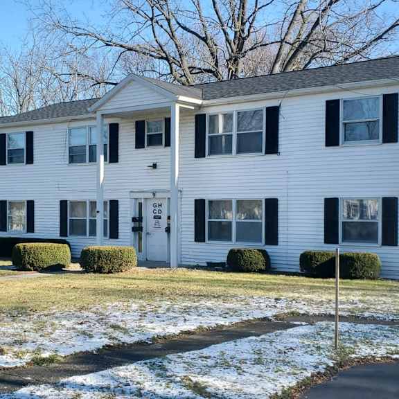 a white house with a yard in the snow