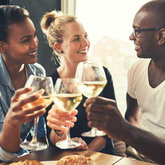 a group of people sitting around a table drinking wine