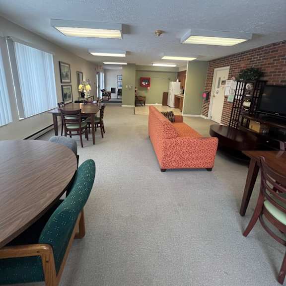 a living room with a couch, chairs, and a dining table.
