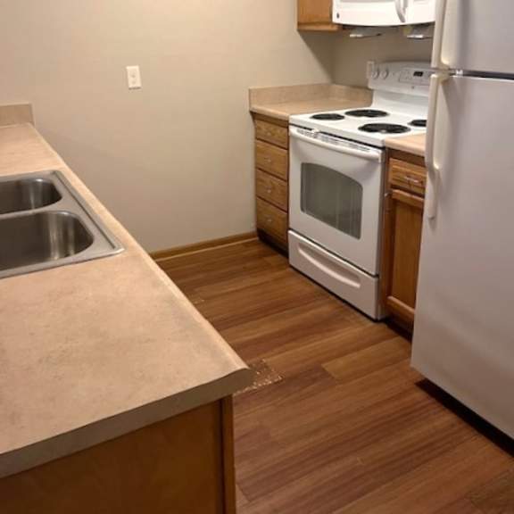a kitchen with a stove and a refrigerator and a sink