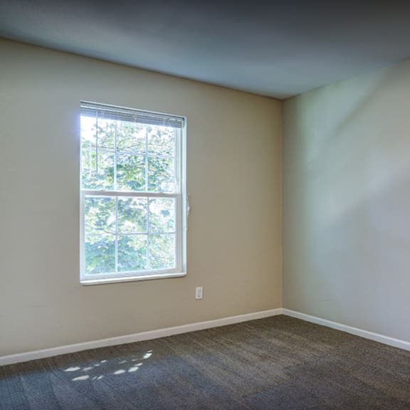 an empty room with white walls and a window