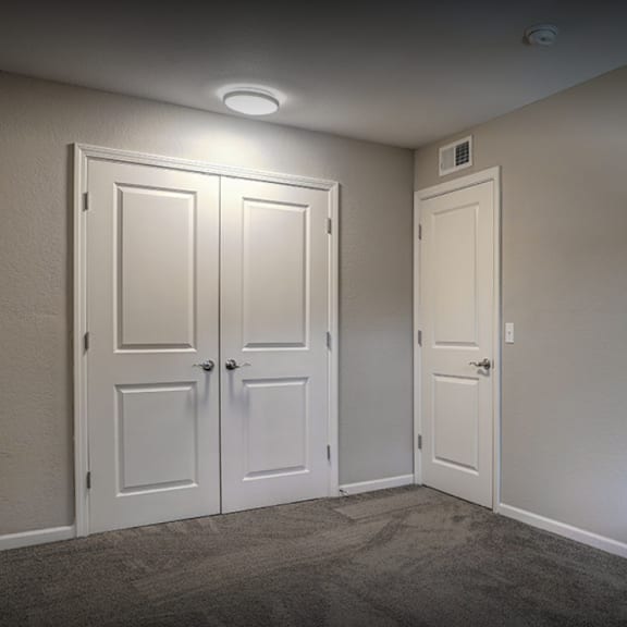 a empty room with two doors and a carpeted floor